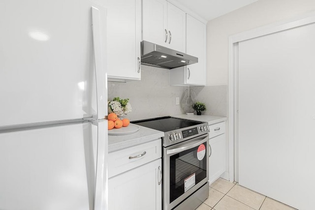 kitchen with white refrigerator, white cabinetry, light tile patterned floors, and electric range