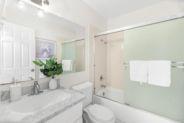 full bathroom featuring vanity, combined bath / shower with glass door, and toilet