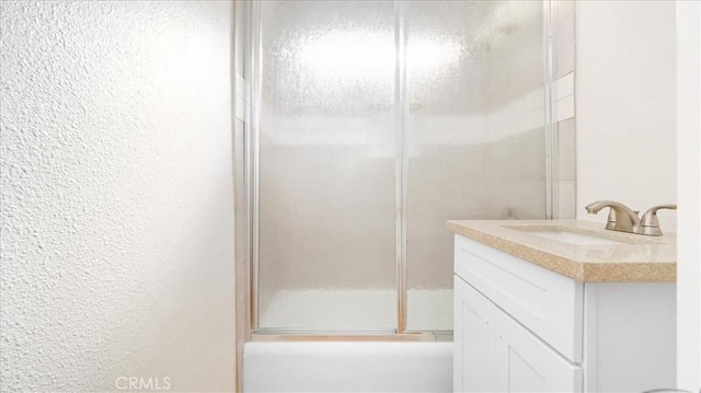 bathroom with vanity and shower / bath combination with glass door