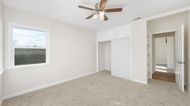 unfurnished bedroom featuring ceiling fan, a closet, and light carpet