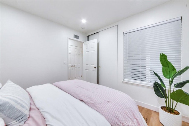 bedroom featuring light hardwood / wood-style floors and a closet