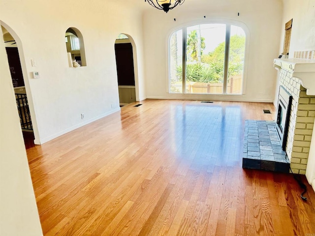 unfurnished living room featuring a fireplace and light hardwood / wood-style flooring