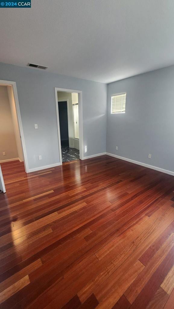 spare room with dark wood-type flooring