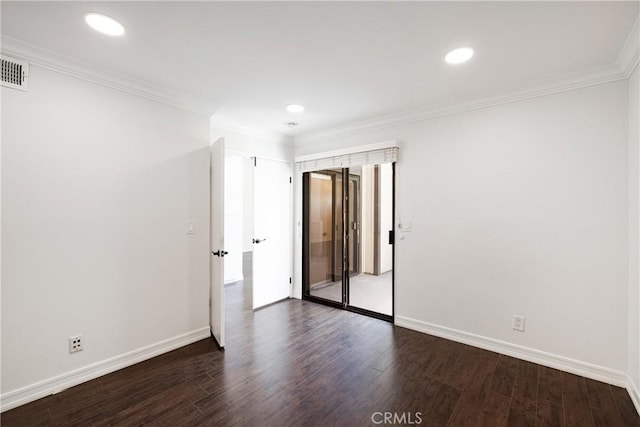 spare room featuring dark wood-type flooring and crown molding