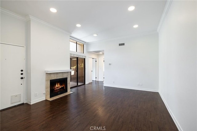 unfurnished living room featuring dark hardwood / wood-style flooring, ornamental molding, and a tile fireplace