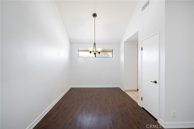 unfurnished dining area featuring vaulted ceiling, hardwood / wood-style floors, and a notable chandelier