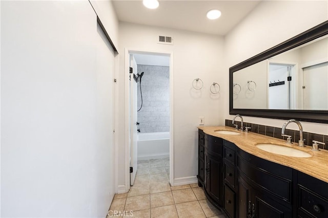 bathroom featuring tiled shower / bath combo, vanity, and tile patterned floors