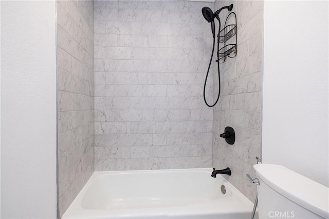 bathroom featuring toilet and tiled shower / bath combo