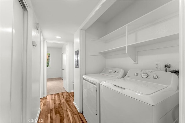 washroom with light hardwood / wood-style floors and washing machine and clothes dryer