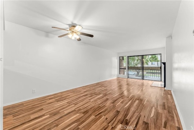 unfurnished living room featuring light wood-type flooring, ceiling fan, and floor to ceiling windows