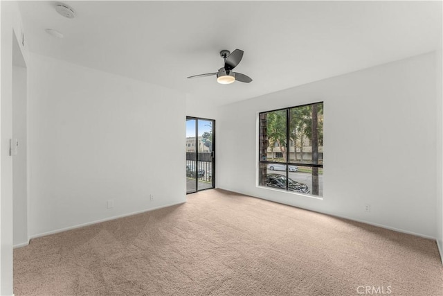 empty room featuring ceiling fan and light colored carpet