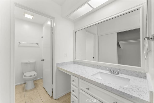 bathroom with toilet, vanity, and tile patterned flooring