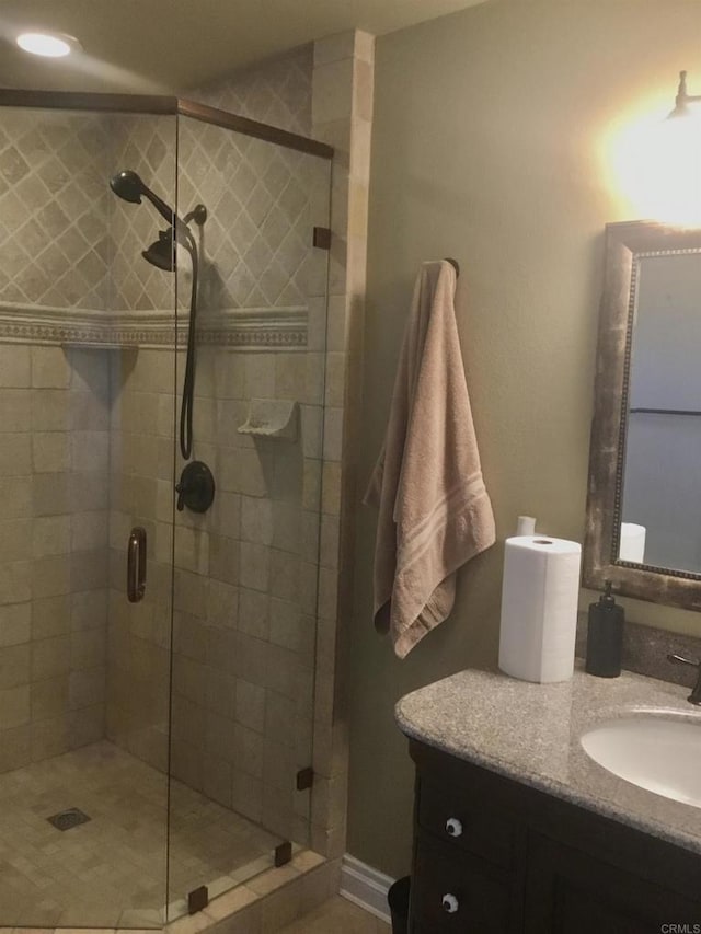 bathroom with a shower with door and vanity