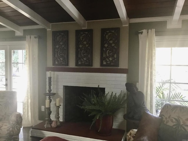 living room featuring beam ceiling and a fireplace