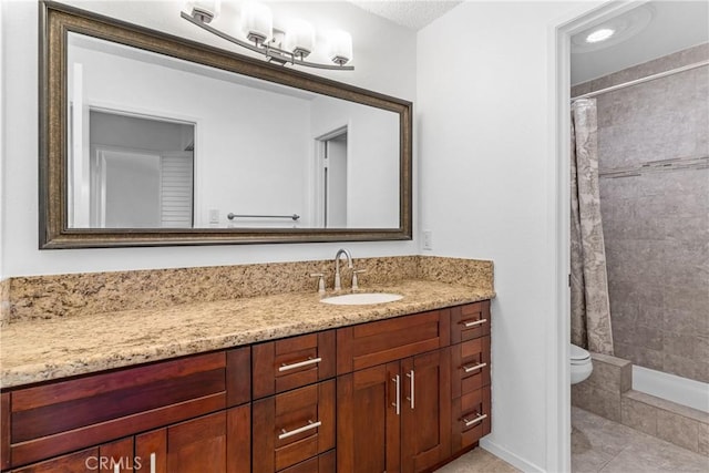 bathroom with a shower with curtain, vanity, tile patterned flooring, and toilet