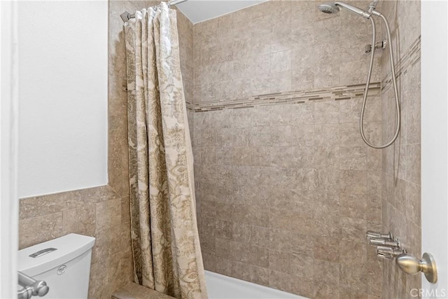 bathroom featuring toilet and tile walls