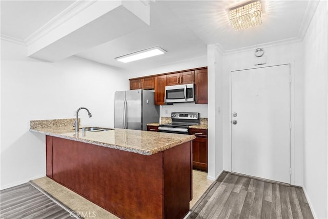 kitchen featuring sink, crown molding, kitchen peninsula, stainless steel appliances, and light hardwood / wood-style floors