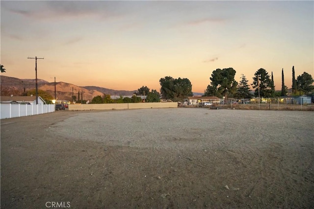 yard at dusk featuring a mountain view