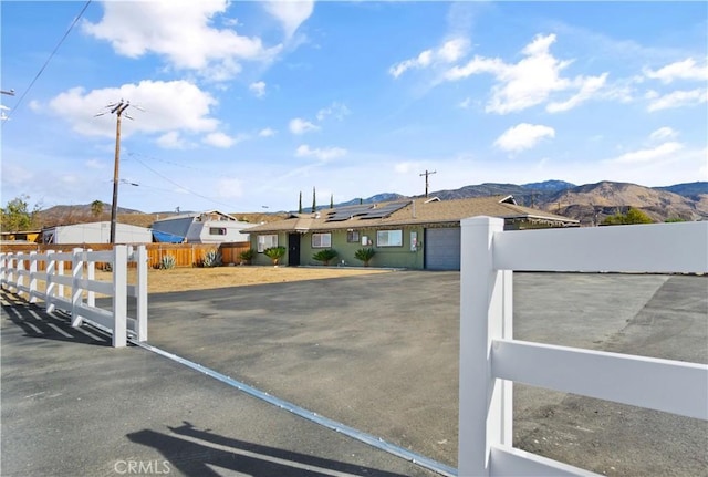 view of front of home with a mountain view and solar panels