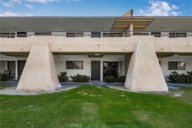 view of front of home featuring a balcony and a front yard