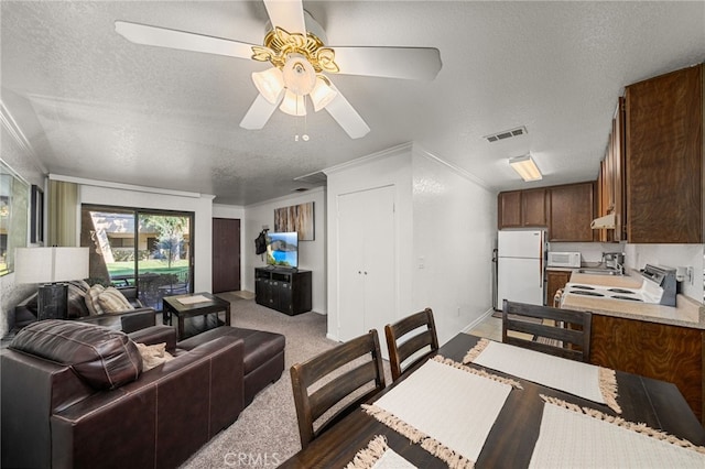 living room with ceiling fan, a textured ceiling, crown molding, and carpet