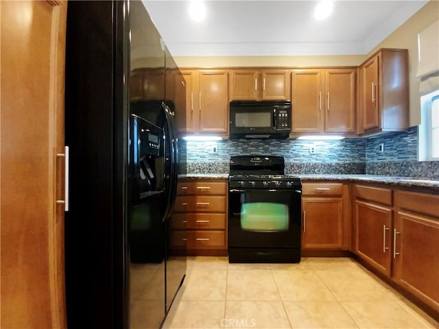 kitchen featuring decorative backsplash, light tile patterned floors, black appliances, and dark stone counters