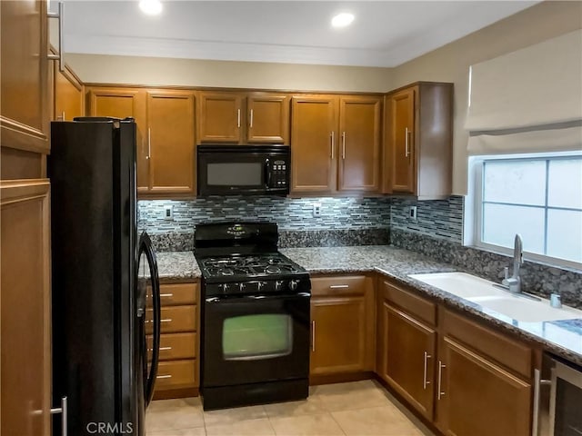 kitchen featuring black appliances, sink, stone countertops, backsplash, and light tile patterned flooring