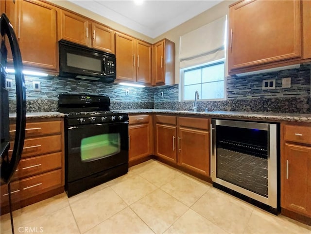 kitchen with light tile patterned flooring, wine cooler, dark stone counters, and black appliances