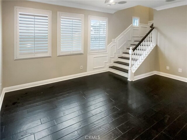 staircase with wood-type flooring and crown molding