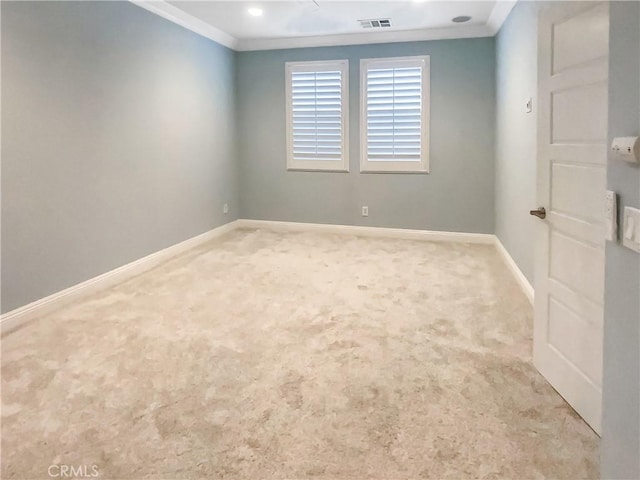 empty room with crown molding and light colored carpet