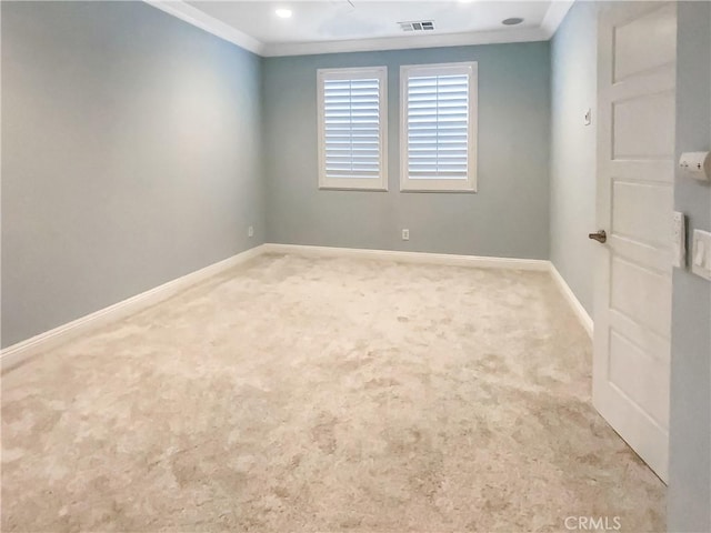 carpeted empty room with visible vents, crown molding, and baseboards