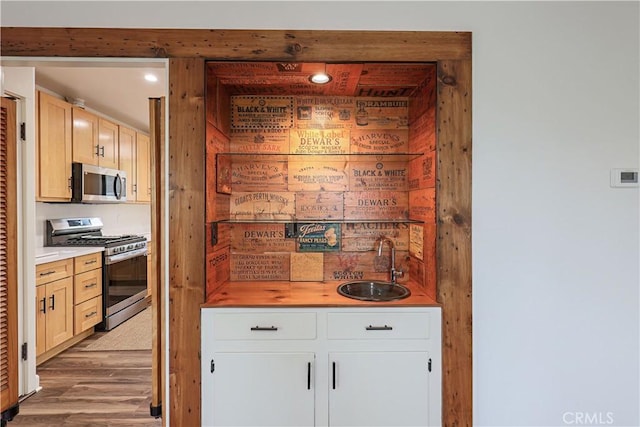 kitchen featuring light hardwood / wood-style floors, sink, white cabinetry, and appliances with stainless steel finishes