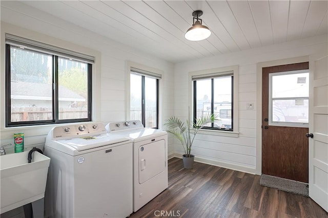 laundry room with washer and clothes dryer, wood walls, wooden ceiling, dark hardwood / wood-style floors, and sink