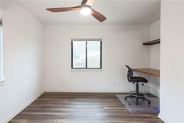 unfurnished office with ceiling fan and dark wood-type flooring