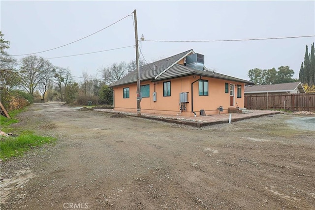 view of side of home with cooling unit and a patio