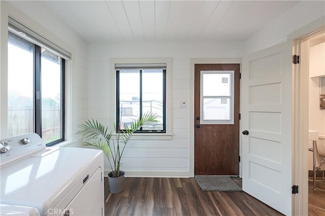 washroom featuring washer and clothes dryer, dark hardwood / wood-style floors, a wealth of natural light, and wooden walls