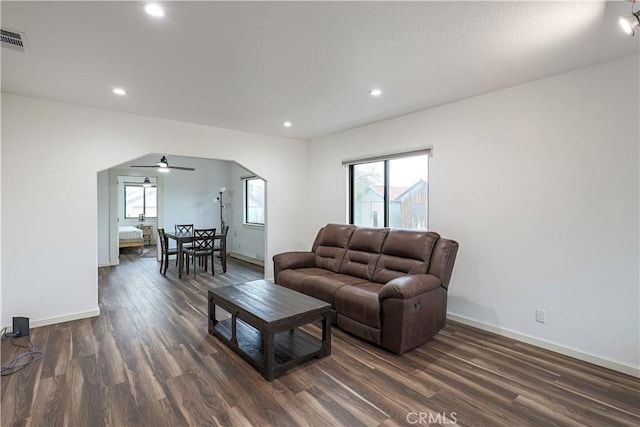 living room featuring ceiling fan and dark hardwood / wood-style flooring