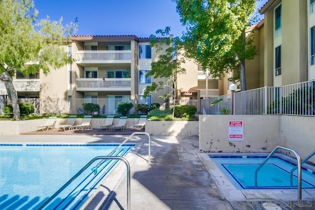 view of swimming pool with a community hot tub and a patio