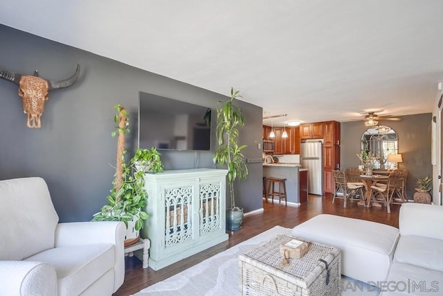 living room with ceiling fan and dark hardwood / wood-style floors