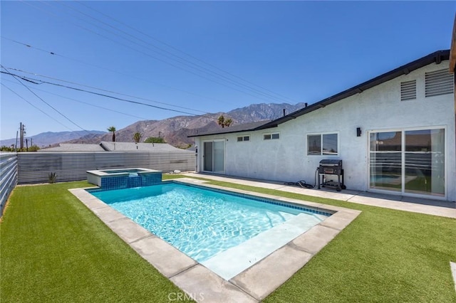 view of swimming pool with a mountain view, an in ground hot tub, and a yard