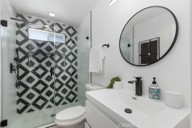 bathroom featuring toilet, a shower with door, and vanity