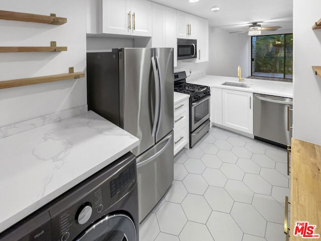 kitchen featuring washer / dryer, white cabinetry, stainless steel appliances, sink, and ceiling fan