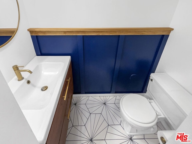 bathroom featuring toilet, vanity, and tile patterned flooring