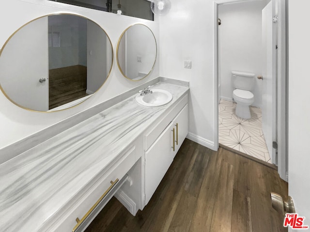 bathroom featuring toilet, hardwood / wood-style floors, and vanity