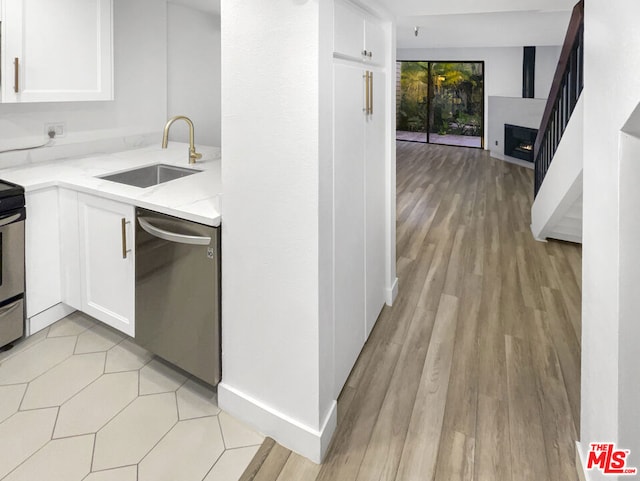 kitchen featuring light stone counters, sink, white cabinetry, and appliances with stainless steel finishes