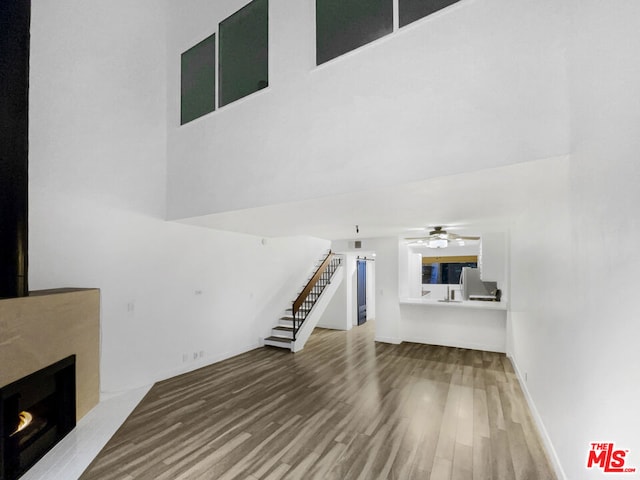 unfurnished living room featuring ceiling fan and hardwood / wood-style floors