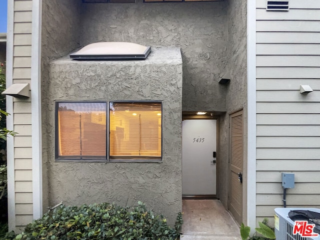 view of exterior entry featuring central AC unit