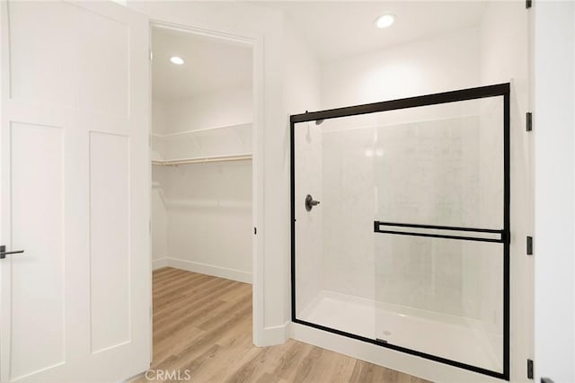 bathroom featuring a shower with shower door and hardwood / wood-style floors