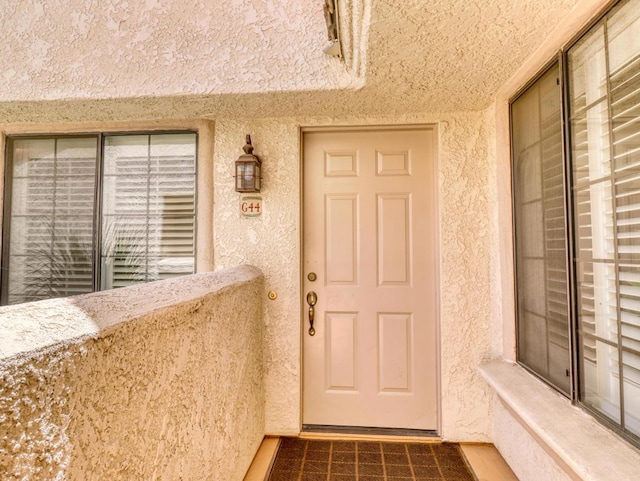 view of exterior entry with a balcony