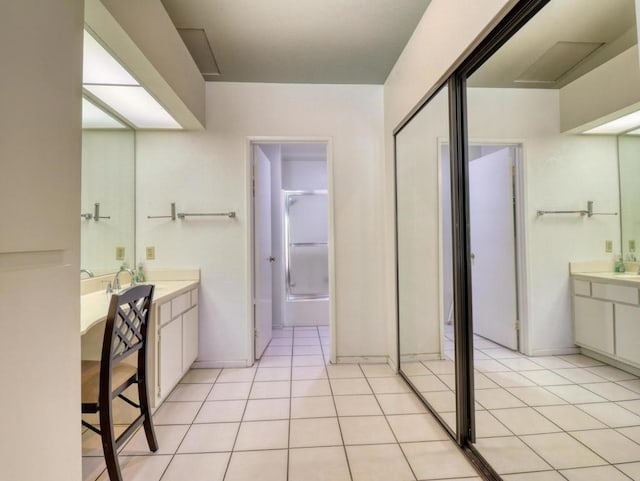 bathroom featuring tile patterned floors, enclosed tub / shower combo, and vanity